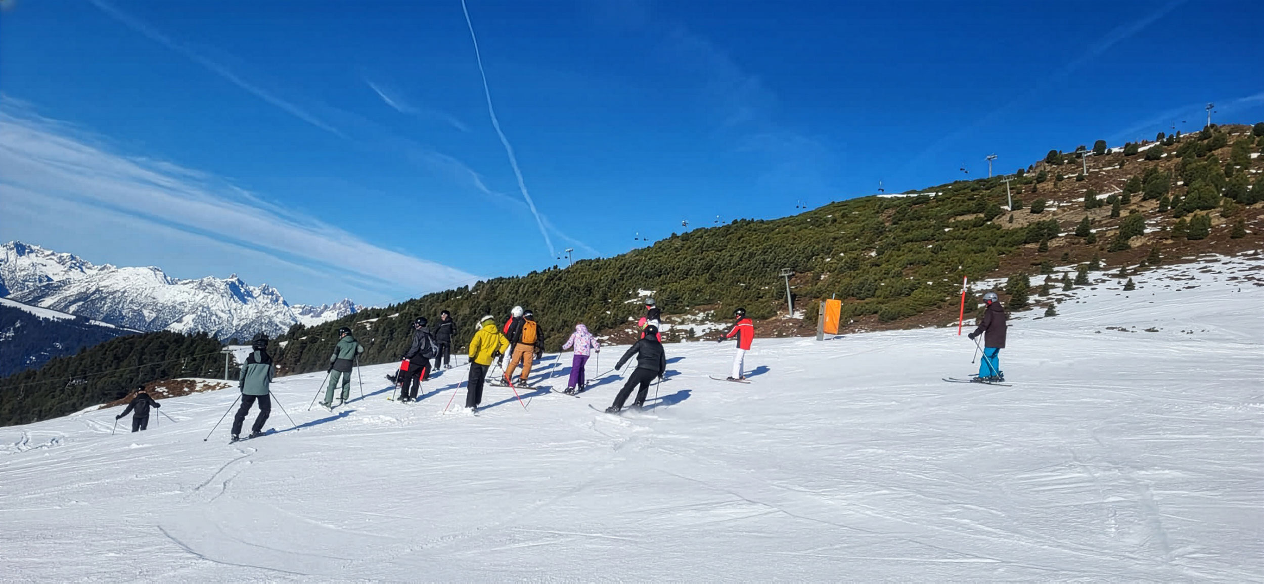 Skifahrer am Hang vor blauem Himmel